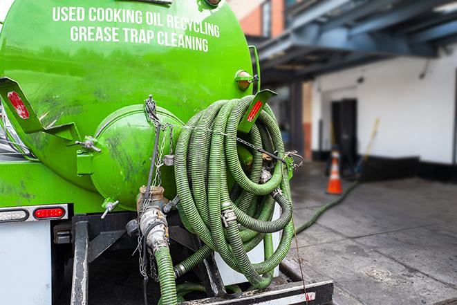 large truck pumping grease trap at a restaurant in East Quogue